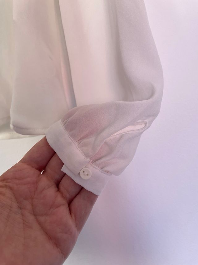 Blusa blanca semitransparente con lazo en cuello