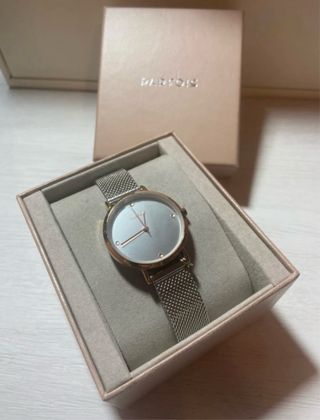 Reloj con etiqueta PRAFOIS dorado y plateado