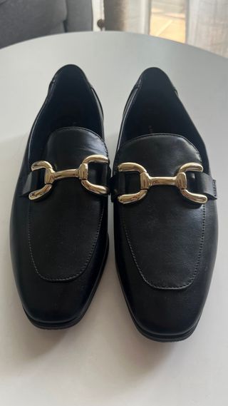 Mocasines negros con hebilla dorada