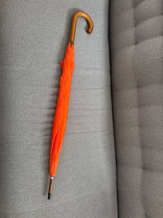 Paraguas naranja con mango de madera