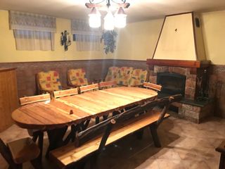 Mesa de madera rústica con bancos y sillas.