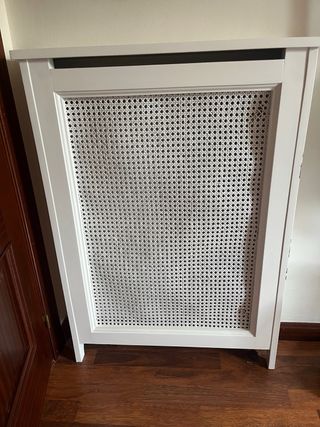 Cubre radiador blanco con rejilla.