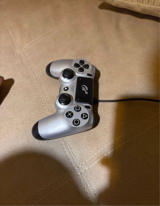 PS4 (PlayStation 4) bianca con controller PS4 argentato.