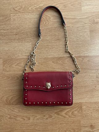 Bolso de mano con tachuelas y detalle de lobo