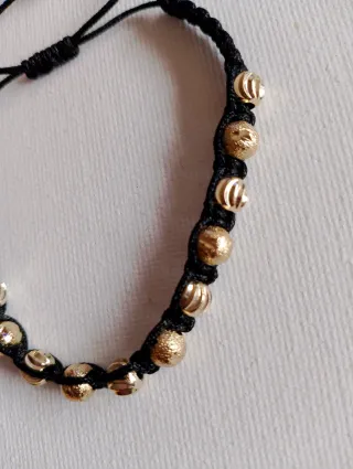 Pulsera negra con cuentas doradas