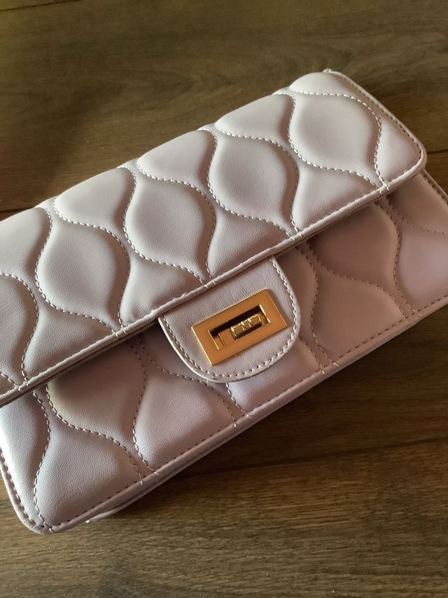 Bolso morado lila con cadena dorada.