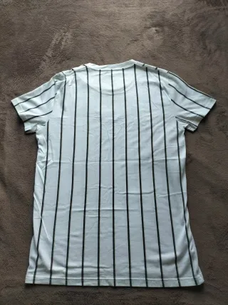 Camiseta Hollister color blanco con rayas negras. 