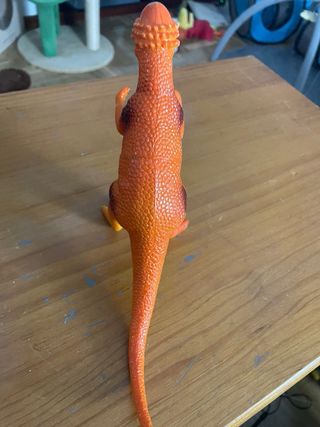 Dinosaurio de juguete naranja y amarillo