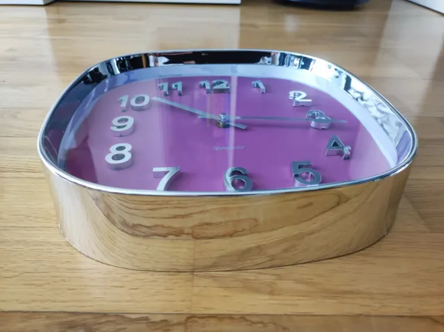 Reloj de pared morado y plata