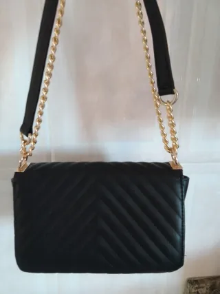Bolso de mano negro con cadena dorada