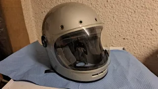 Casco de moto plateado con visera