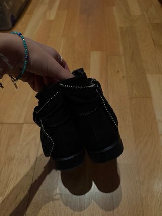 Botas negras con detalle de tachuelas.
