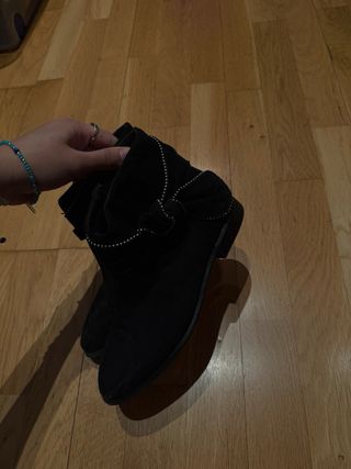 Botas negras con detalle de tachuelas.