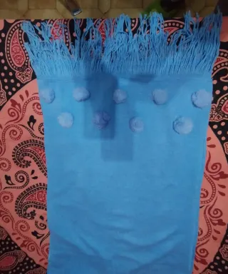 Bufanda azul con pompones y flecos
