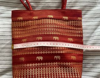 Bolso de mano rojo con elefantes dorados