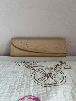 Bolso de mano dorado con perlas