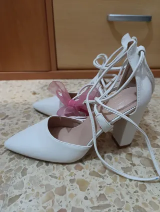 Zapatos de tacón blancos con cordones.
