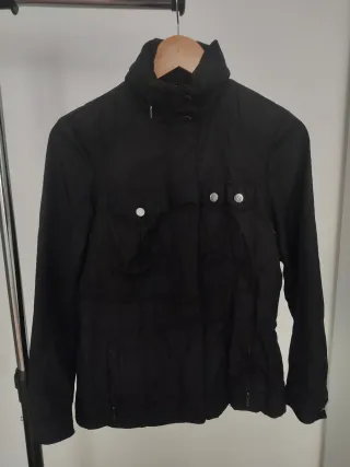 Chaqueta negra con capucha que se guarda.