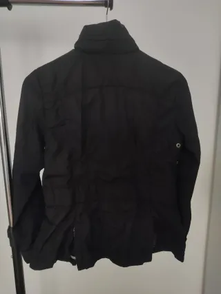 Chaqueta negra con capucha que se guarda.