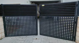 Puerta negra de hierro con doble hoja para cochera