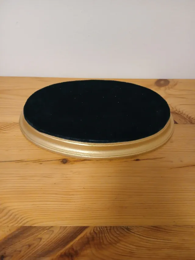 Peana dorada con base de terciopelo.