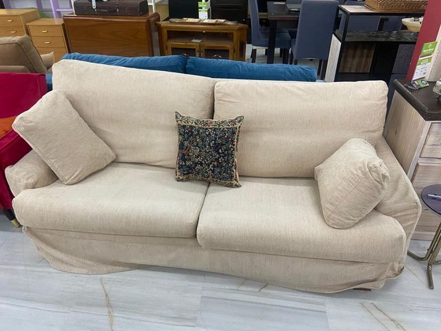 Sofá beige claro con cojines