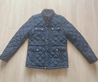Chaqueta acolchada azul con coderas marrones.