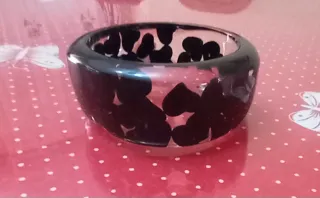 Pulsera ancha negra con diseño de corazones.