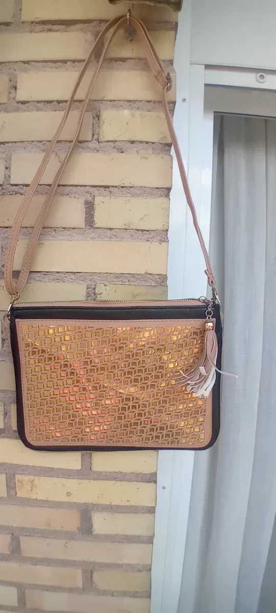 Bolso de hombro dorado con diseño geométrico