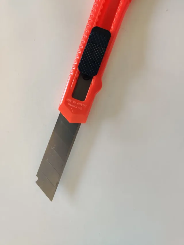 Cúter retráctil color rojo