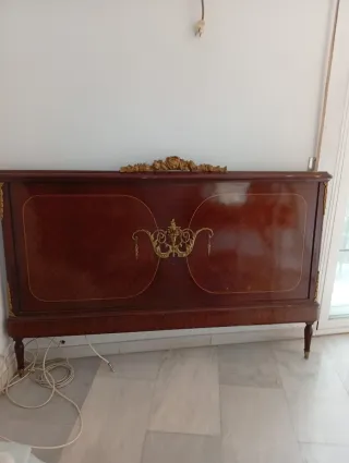 Tocador antiguo con espejo, mesitas y cabecero.