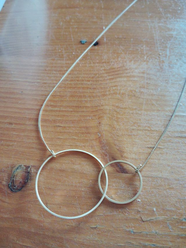 Collar dorado con dos aros entrelazados