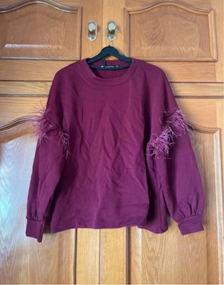 Sudadera morada con plumas