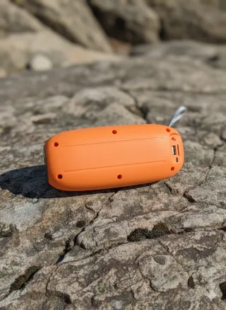 Altavoz portátil RT naranja con sonido HD y luces.
