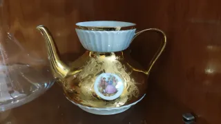 Tetera de porcelana dorada con escena
