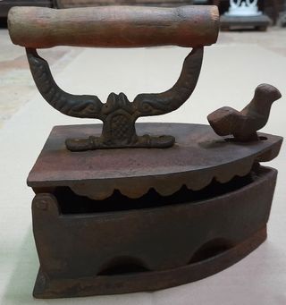 Plancha antigua de hierro con adorno de pájaro