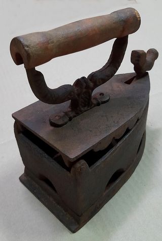 Plancha antigua de hierro con adorno de pájaro