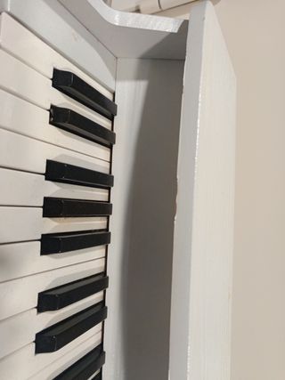 Piano infantil de madera blanco.