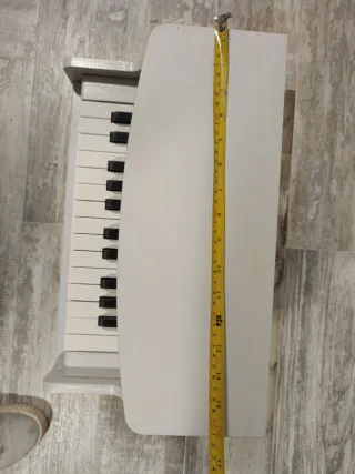 Piano infantil de madera blanco.