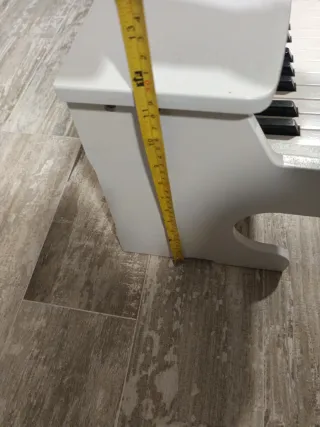 Piano infantil de madera blanco.