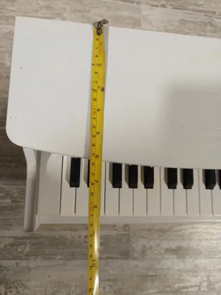 Piano infantil de madera blanco.