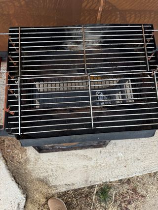 Barbacoa de carbón con mesas laterales