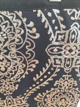 Falda corta negra con lentejuelas doradas.