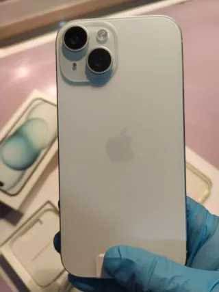 iPhone 15 azul/blanco + Fundas negra y transpare.