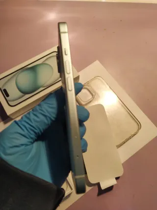 iPhone 15 azul/blanco + Fundas negra y transpare.