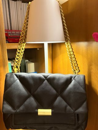 Bolso negro acolchado con cadena dorada