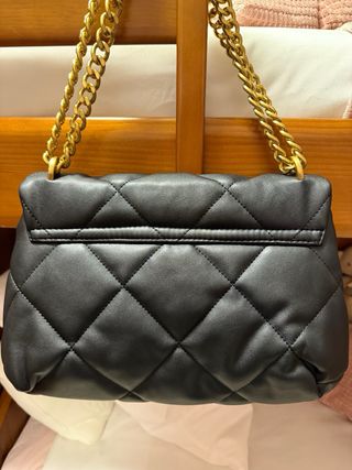 Bolso negro acolchado con cadena dorada