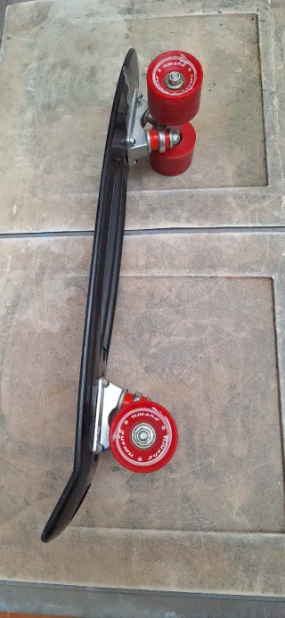 Monopatín negro con ruedas rojas