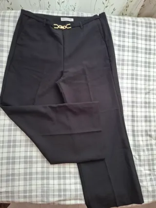Pantalón negro con cinturón dorado