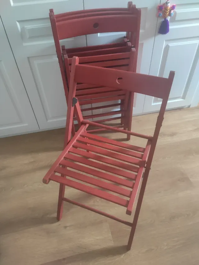 Cuatro silllas plegables de madera rojas